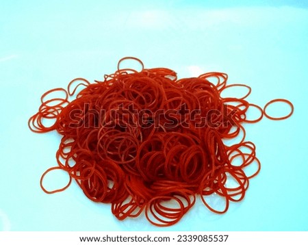 There are many piles of bright red rubber bands.