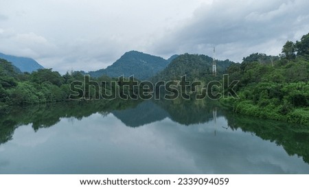 Beautiful natural view of river in tropical rain forest in Lamseunia village Aceh Province Indonesia with mountains in the background, aerial view drone shot