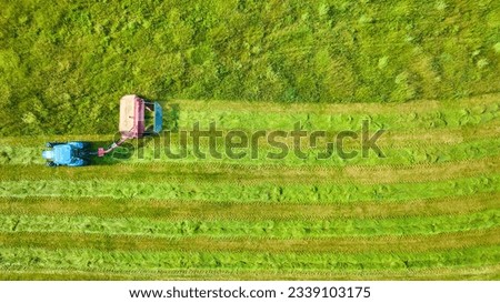 Downward view of tractor mowing weeds in field aerial background asset