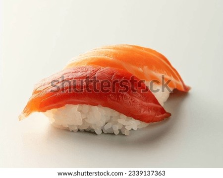 Nigiri Sushi is a food originating from Japan. Nigirizushi is a sushi dish consisting of small pieces of rice covered with pieces of fish or other seafood.  Close-up of Delicious Sushi Rice Dish with  Royalty-Free Stock Photo #2339137363