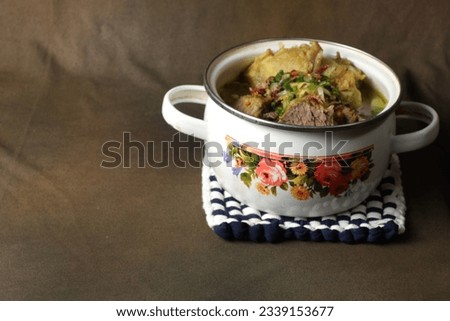 Beef soup in a white bowl on a brown base