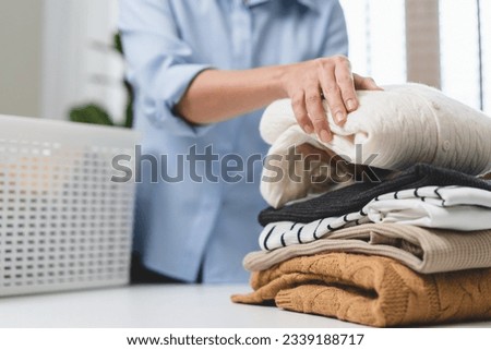 Laundry household work concept, asian woman working on fresh clean clothes.