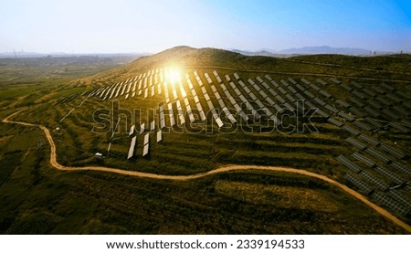 Aerial photography of solar photovoltaics on a hillside illuminated by the setting sun