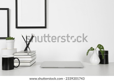 Home workplace. Laptop, stationery and houseplants on white wooden desk