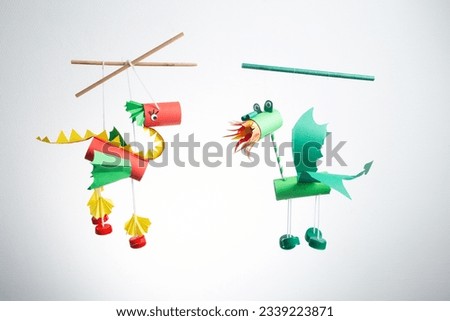 two dragon marionettes, recycled craft, DIY, easy Chinese New Year Crafts and ideas for kids, toilet paper roll craft, red and green dragons toy, marionette from recycled materials Royalty-Free Stock Photo #2339223871