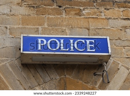 A photograph of an old Police sign lamp outside a building