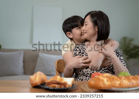 Son kissing happy mother, holiday at home