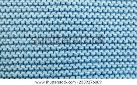 Close up background of knitted blue wool fabric knitwear texture. 