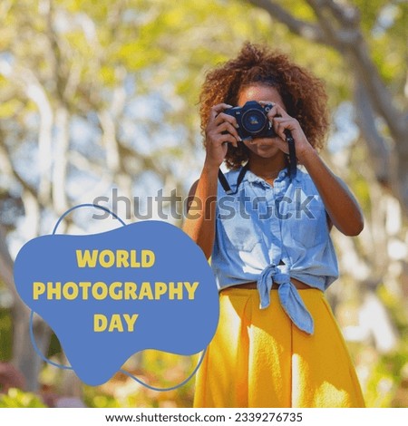 World photography day text in yellow on blue over african american woman using camera in sunny park. Global celebration of photography campaign, digitally generated image.