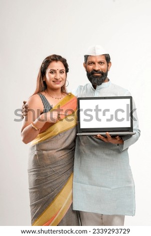 Indian man and woman showing laptop screen on white background.