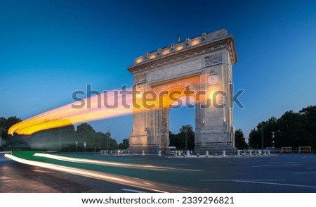 Arch of Triumph in Bucharest, travel to Romania. Long exposure photo with traffic lights in the morning blue hour sky. Beautiful landscape photo of Bucharest. Royalty-Free Stock Photo #2339296821