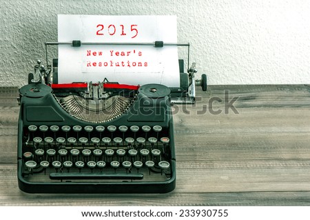 Typewriter with white paper page on wooden table. sample text 2015 New Year's Resolutions. vintage style toned picture