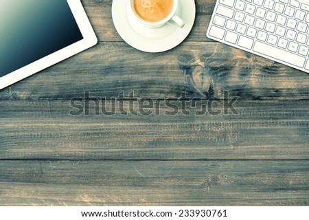 digital tablet pc, keyboard and cup of coffee on wooden table. mock up. vintage style toned picture