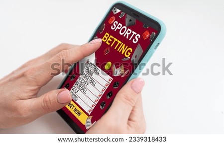 Hand holding smart phone with sports betting concept on screen. All screen content is designed by me