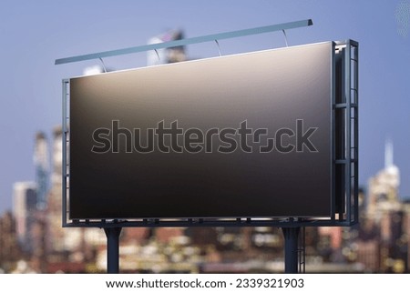 Blank black horizontal billboard on cityscape background at night, perspective view. Mockup, advertising concept