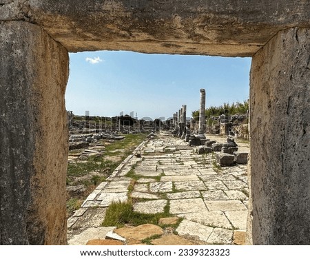 Perge ancient city in Antalya, Turkey. Pergian way with columns in natural stone wall frame