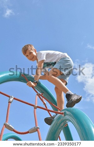 boy 10 years old on the playground on the ropes Royalty-Free Stock Photo #2339350177