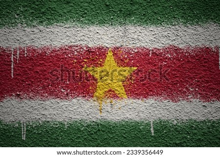 colorful painted big national flag of suriname on a massive old cracked wall