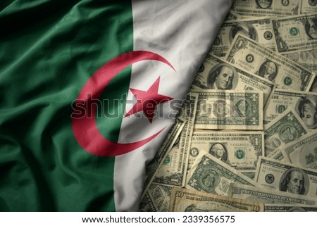 big colorful waving national flag of algeria on a american dollar money background. finance concept
