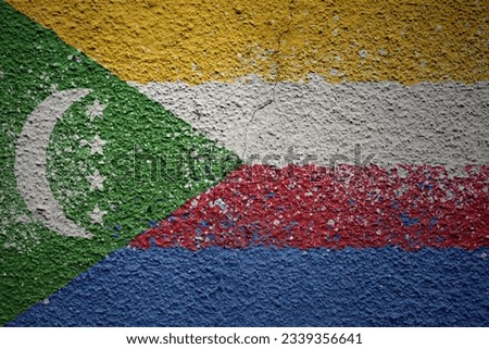 colorful painted big national flag of comoros on a massive old cracked wall