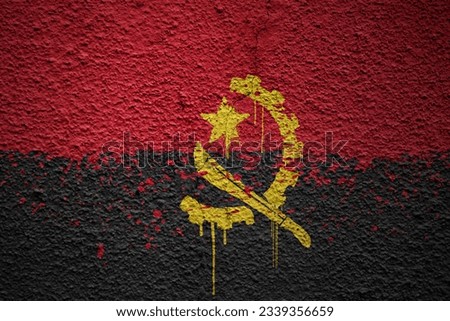 colorful painted big national flag of angola on a massive old cracked wall