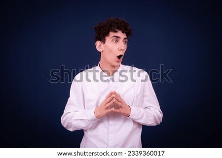 Funny emotional guy is preparing for exams. Student posing on a blue background.