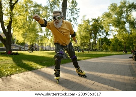Funny mature man wearing goggles riding fast on roller skates