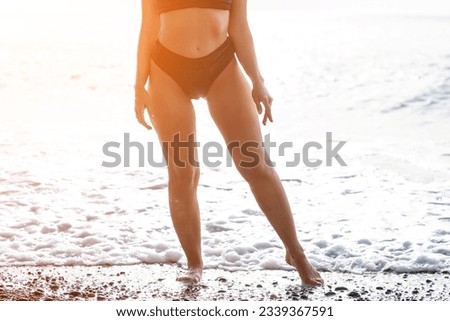 Woman summer travel sea. Happy woman enjoying her summer travels, captured in a lower body portrait, taking photos to preserve her memories of the scenic sea beach sharing travel adventure journey