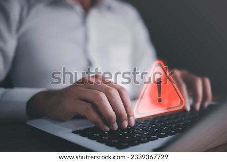 Businessman or it staffs, programmer, developer using computer laptop with triangle caution warning sign for notification error and maintenance concept. Virus detected warning, Cybercrime protection