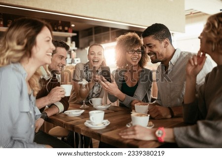 Diverse group of young people talking and having a coffee at a cafe Royalty-Free Stock Photo #2339380219
