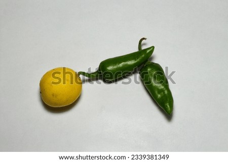 close up to view of fresh chillies and lemon displayed in white background 