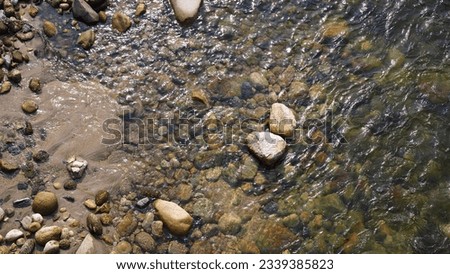 A shallow river and some river rocks Royalty-Free Stock Photo #2339385823