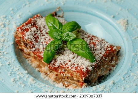 Traditional Italian cuisine vegetarian lasagna with eggplant tomato sauce, basil, garlic and cheeses - parmigiana   Royalty-Free Stock Photo #2339387337