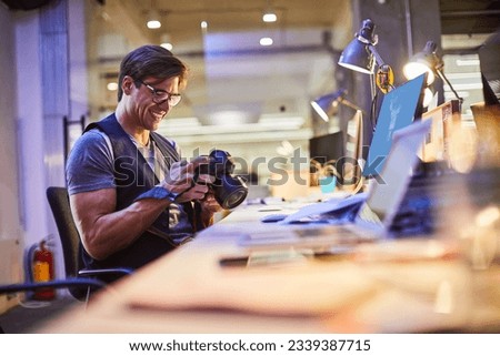 Young male photographer working in the office