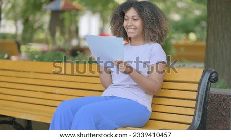 Young African Woman Celebrating while Reading Contract Outdoor