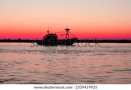 Fishing boat leaving port at nightfall. Fishing industry in andalusian coast, Spain  Royalty-Free Stock Photo #2339419925