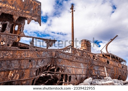 Close up of rusty and broken metal of wrecked ship Plassey on rocky beach, important and popular tourist attraction, sunny day with deep blue sky and white clouds on Ara Island, Ireland Royalty-Free Stock Photo #2339422955