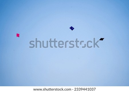 fighting kites flying against a deep blue sky in jaipur, ahmedabad, delhi on the festival of sankranti, uttarayan, independence day showing celebrations Royalty-Free Stock Photo #2339441037