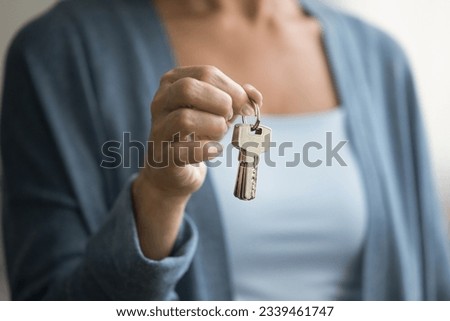 Female hand showing key from apartment, new house, home. Senior new owner woman, seller, realtor promoting real estate investment, property buying, rental service Royalty-Free Stock Photo #2339461747