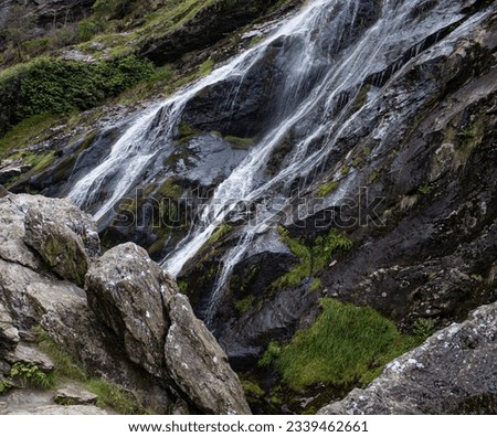 Waterfall outdoor beautiful nature mossy long high mountain cliffs with water in Ireland
