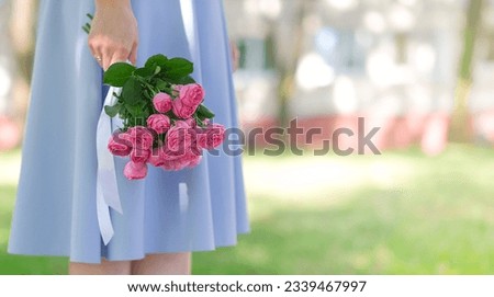 International Women's Day.Concept of greeting banner for international women's day on March 8.Close-up girl's hands holding large bouquet pink roses on pink background, copy space. Mother's day banner