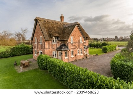 Countryside new build detached house with thatched roof Royalty-Free Stock Photo #2339468623
