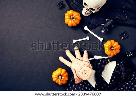 Happy Halloween holiday concept. Wednesday girl dress, hair, the thing hand, pumpkins, skull, bones on black background