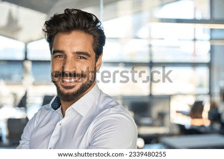 Happy young Latin business man standing in office, headshot close up portrait. Smiling Hispanic businessman manager, successful entrepreneur, male professional executive looking at camera. Royalty-Free Stock Photo #2339480255
