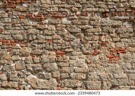 Old red brick wall background. Texture of an old ancient stone wall. Stonewall background.
