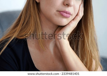 Girl with her face resting on her hand. Toothache. Depression. Mental health. Focus on the hand. Royalty-Free Stock Photo #2339481401
