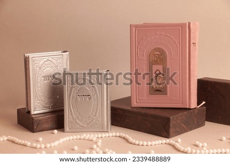 jewish Prayer books. On the pink book it is written: "Open the gates of heaven to our prayers", on the other books is written: "Sydur"  Royalty-Free Stock Photo #2339488889