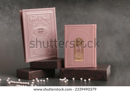 jewish Prayer books. On one book it is written: "Open the gates of heaven to our prayers". On the second book is written: "The Food Blessing"