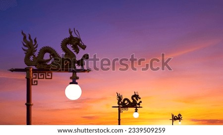 Silhouette high section of Chinese dragon street lamp posts against beautiful sunset sky background in perspective widescreen view Royalty-Free Stock Photo #2339509259
