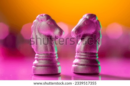 colored background with two chess horses on a pink-yellow background
